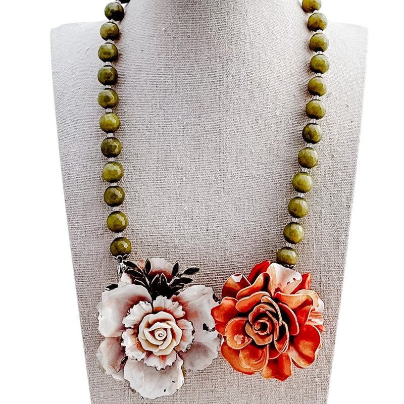 Necklace with floral pendants on a mannequin bust against a white background