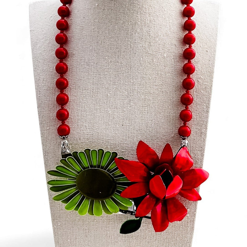 Necklace with red beads and floral pendant on a mannequin bust