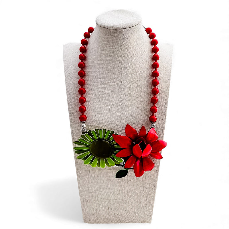 Necklace with red beads and floral pendant on a mannequin bust