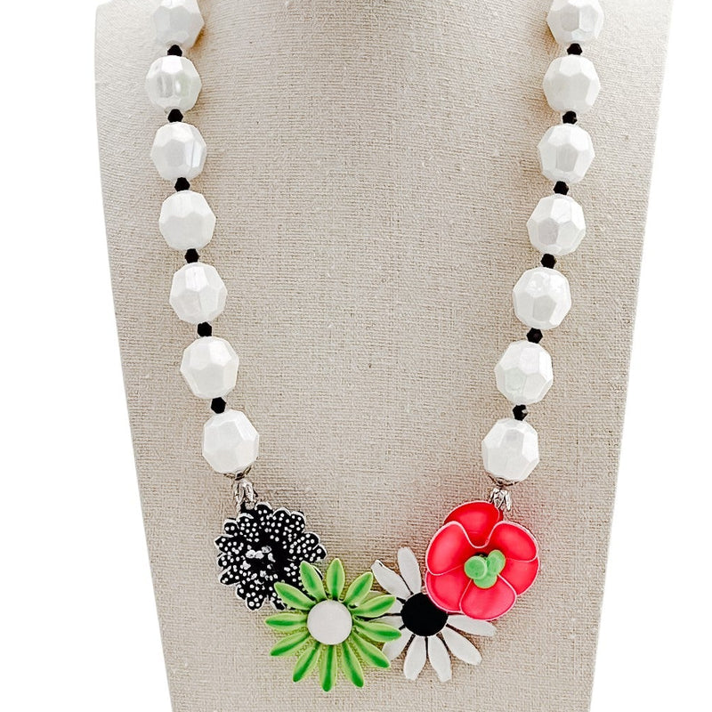 Necklace with floral pendants on a mannequin bust against a white background