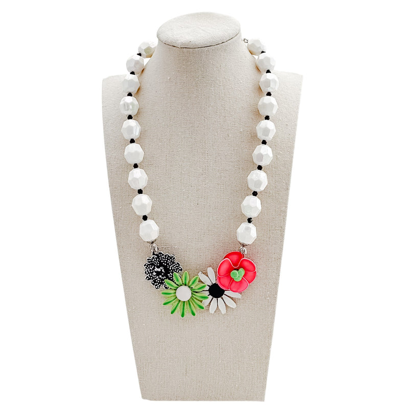 Necklace with floral pendants on a mannequin bust against a white background