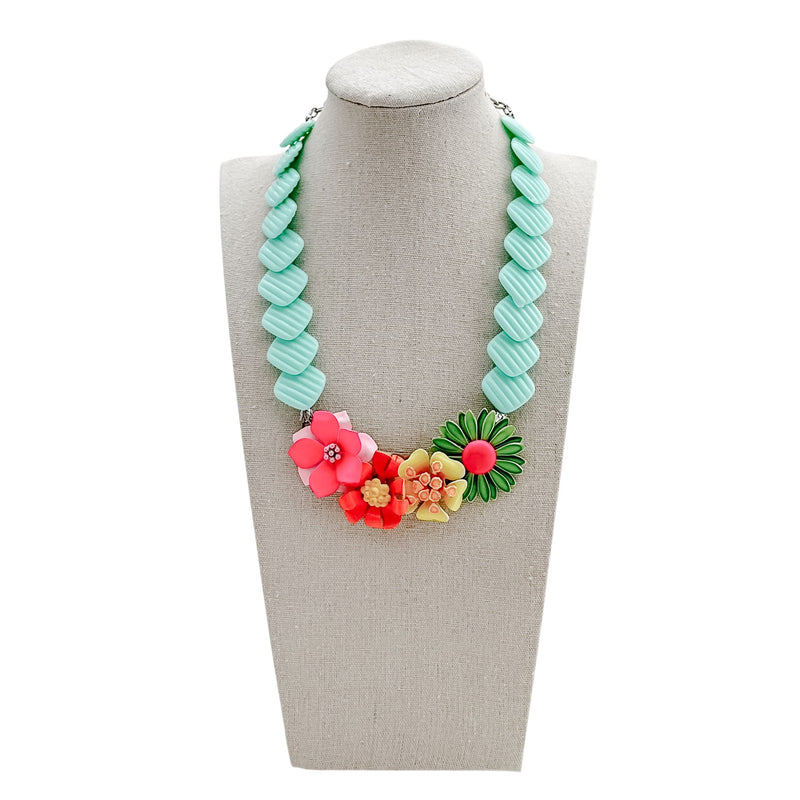 Necklace with floral pendants on a mannequin bust against a white background