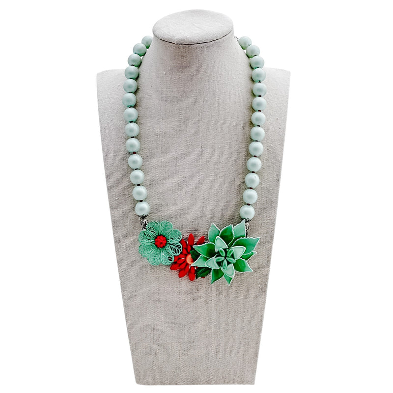 Necklace with floral pendants on a mannequin bust against a white background