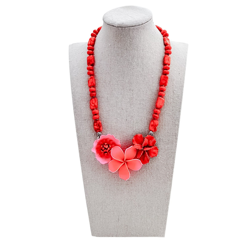 Red beaded necklace with pink floral pendants on a gray mannequin bust.