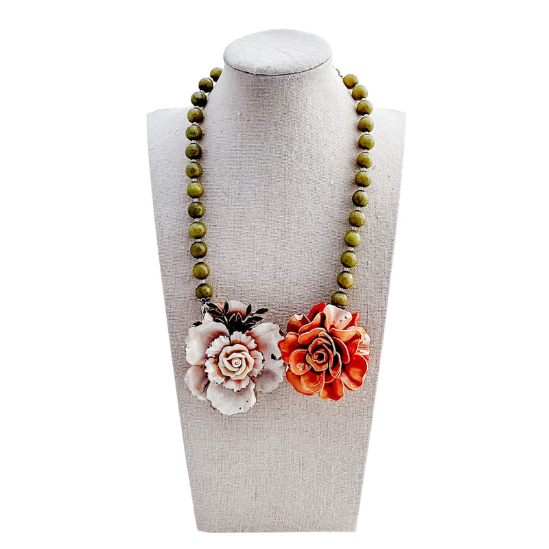 Necklace with floral pendants on a mannequin bust against a white background