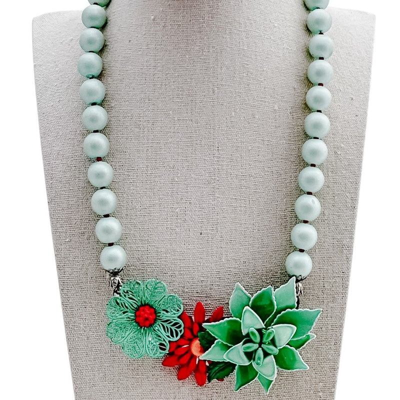 Necklace with floral pendants on a mannequin bust against a white background